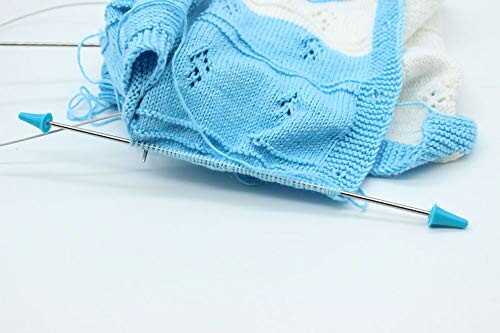 Blue and white knitted fabric with knitting needles.